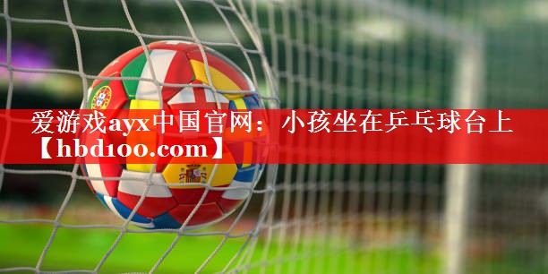 爱游戏ayx中国官网：小孩坐在乒乓球台上